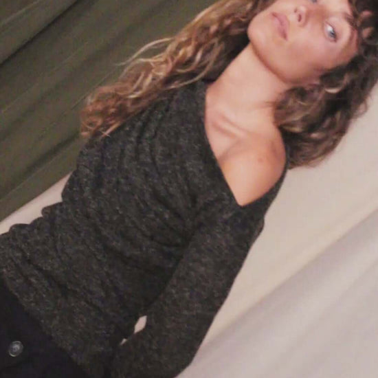 Model wearing a black recycled jersey drape top with draped neckline and thumb holes, showcasing autumn style.