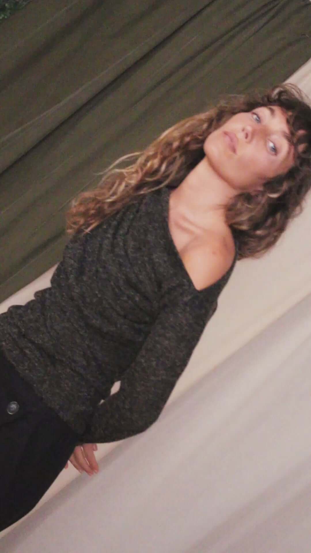 Model wearing a black recycled jersey drape top with draped neckline and thumb holes, showcasing autumn style.