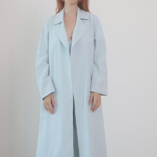Organic Cotton Wide Jumpsuit in Pale Blue worn with a light coat, showcasing a relaxed and stylish warm-weather look.