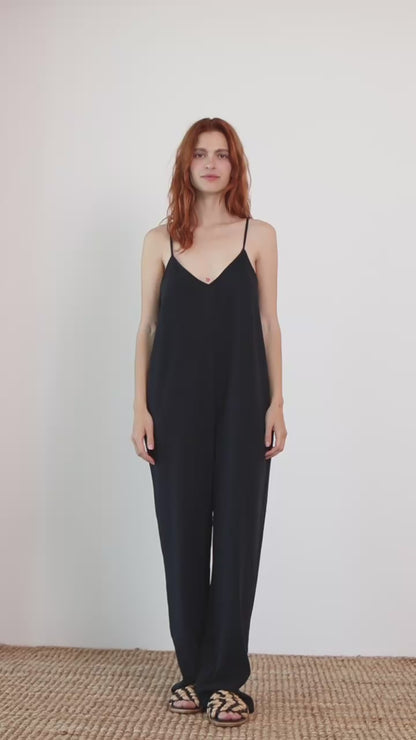 Wide Organic Cotton Strappy Jumpsuit in Black worn by a model, showcasing a relaxed silhouette and slim straps.