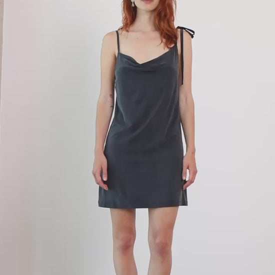 Cupro Drape Slip Mini Dress in Slate Black worn by model, featuring adjustable straps and a flattering draped neckline.