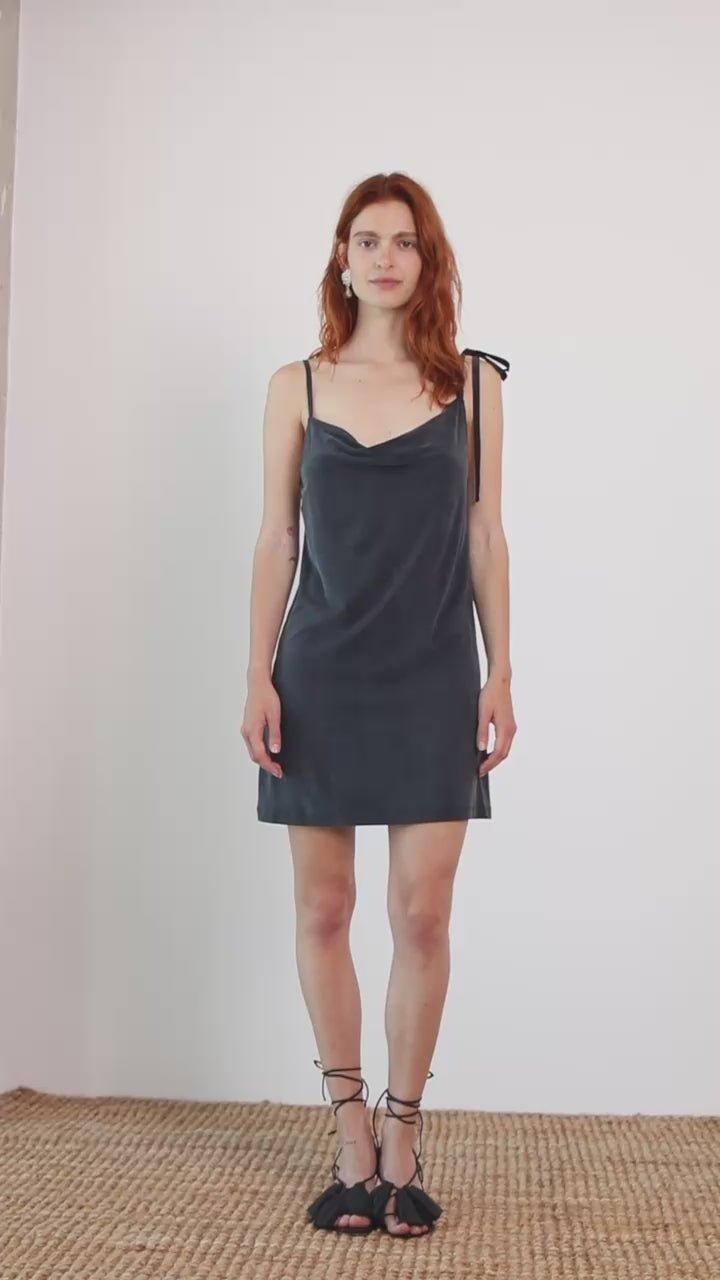 Cupro Drape Slip Mini Dress in Slate Black worn by model, featuring adjustable straps and a flattering draped neckline.