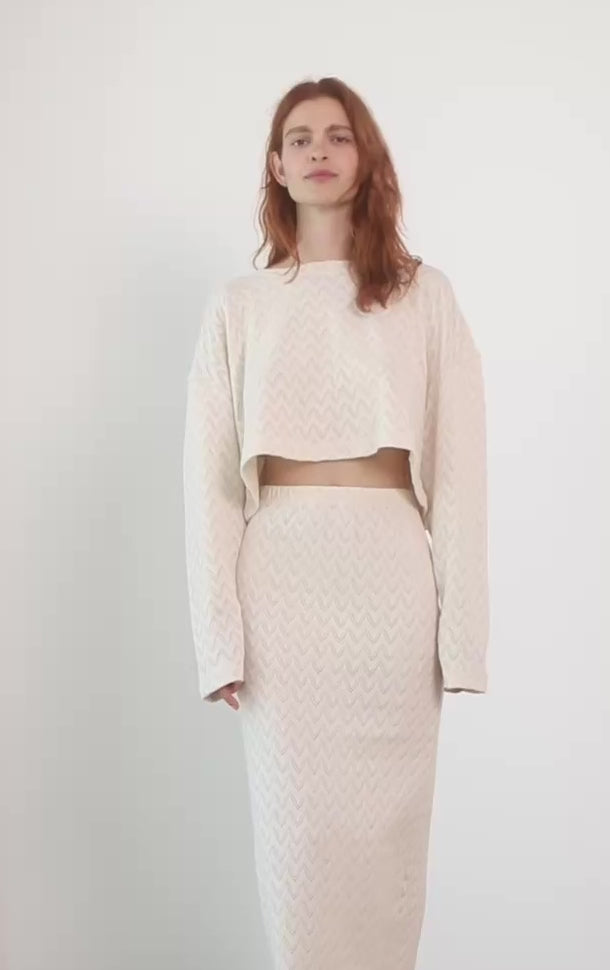 Model wearing a Crochet Organic Cotton Long Sleeve Top with a matching skirt in ecru color.