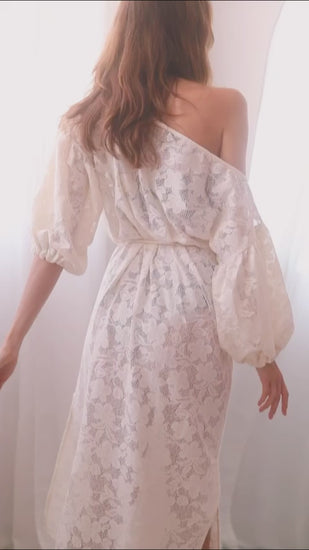 Back view of a woman in an elegant ecru lace boho maxi dress with balloon sleeves and a lace belt.
