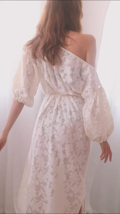Back view of a woman in an elegant ecru lace boho maxi dress with balloon sleeves and a lace belt.
