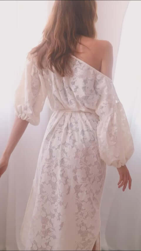 Back view of a woman in an elegant ecru lace boho maxi dress with balloon sleeves and a lace belt.