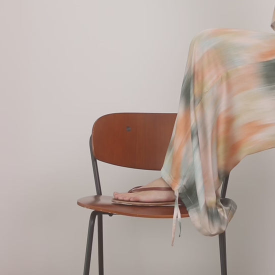 Printed Ecovero Viscose Wide-Leg Trousers draping effortlessly over a wooden chair.