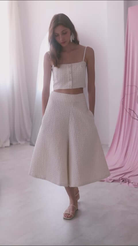 Model wearing ecru waffle skirt culottes paired with a matching crop top in a light room.