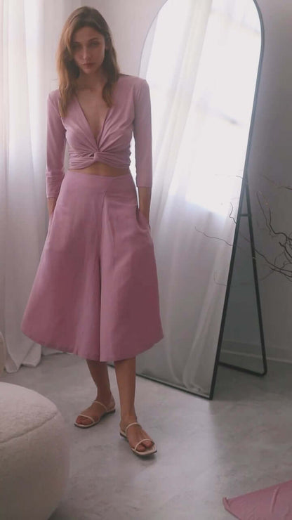 Model wearing rose skirt culottes styled with a matching wrap top, showcasing elegance and comfort.