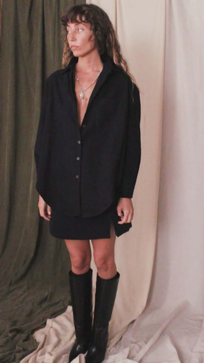 Model wearing a black organic cotton wide overshirt, styled for autumn layering, with a modern minimalist look.