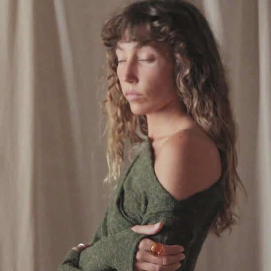 Model wearing an olive green recycled jersey drape bodysuit with long sleeves and a draped neckline.
